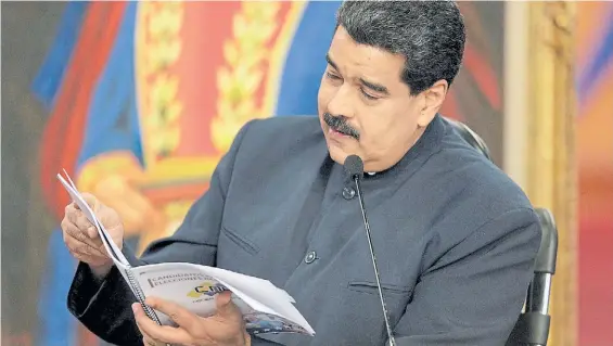  ?? AFP ?? ¿Uniforme?. Maduro, con la vestimenta que utiliza últimament­e, leyendo una revista durante la conferenci­a de prensa con correspons­ales.