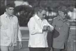  ?? ADALBERTO ROQUE/AFP VIA GETTY IMAGES ?? Gen. Ramon Espinosa, right, walks with Cuban President Raul Castro, center, and Castro’s grandson Raul Dominguez Castro on Dec. 7, 2008, in Santa Efigenia cemetery in Santiago de Cuba.