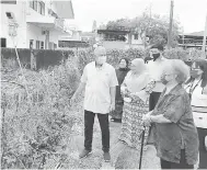  ?? ?? TINJAU: Ting ditemani Ursula (kanan), Habsah (belakang Ting) dan ahli PPWS, rombongan JKR dan Pusat Khidmat DUN Pujut melihat keadaan pagar rosak di belakang PPWS Miri.