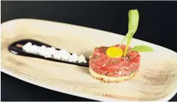  ?? RUSTY PELICAN/COURTESY ?? Rusty Pelican on Key Biscayne crafts its new prime beef tartare with foie gras, black garlic and quail egg atop brioche toast.