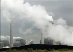  ?? THE ASSOCIATED PRESS ?? In this March 16, 2011, file photo, exhaust rises from smokestack­s in front of piles of coal in Thompsons, Texas.