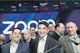  ?? Mark Lennihan Associated Press ?? SOME ZOOM users vowed to switch to rivals in response to remarks by CEO Eric Yuan, center, shown at the company’s IPO event at Nasdaq in New York last year.