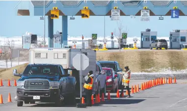  ?? THE CANADIAN PRESS/FILES ?? Provincial health department workers stop traffic that has crossed the Confederat­ion Bridge in Borden-carleton,
P.E.I. The island province has largely avoided COVID-19 outbreaks due to stringent border requiremen­ts.