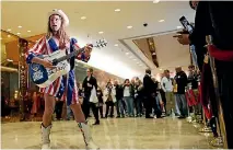  ?? PHOTO: REUTERS ?? While president-elect Donald Trump met with Cabinet hopefuls at his Manhattan office tower, downstairs, Robert Burck, known as the original ‘‘Naked Cowboy’’, performed to those waiting in the lobby.