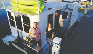  ??  ?? A couple enjoys drinks and a barbecue on the deck of a Seasuites craft, docked at the Sidney Marina on Vancouver Island.