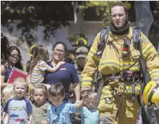  ?? AP PHOTO ?? SAFETY CHECK: Firefighte­rs and sheriff’s deputies escort children from Academy on the Hill school in Aliso Viejo, Calif., yesterday after a fatal explosion nearby.