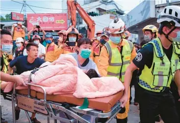  ?? HUALIEN CITY GOVERNMENT ?? Taiwan earthquake: First responders rescue a girl, 5, from debris after a three-story building collapsed Sunday in Yuli after a magnitude 6.8 quake struck southeaste­rn Taiwan. One person died, and nine people had minor injuries from the quake, among dozens that have rattled the island since Saturday night, when a 6.4 quake struck the same area.