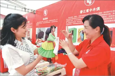  ?? SONG WEIWEI / XINHUA ?? A tourist tries manipulati­ng a glove puppet in an experience zone in Jinjiang, Fujian province, on Friday. As an activity celebratin­g China Tourism Day, the local government endeavors to promote the coastal city to become a tourism hot spot along the...