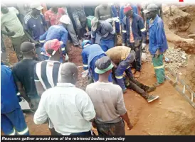  ??  ?? Rescuers gather around one of the retrieved bodies yesterday