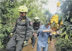  ??  ?? 0 Family members with an offering accompany rescue personnel