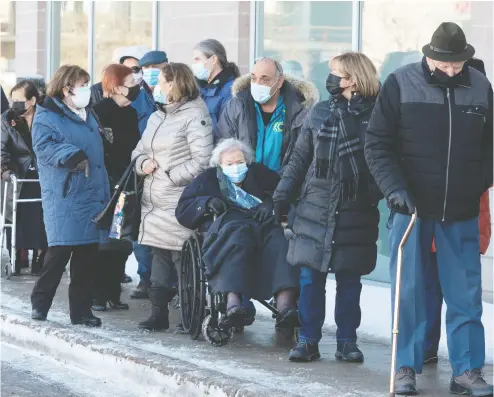  ?? RYAN REMIORZ / THE CANADIAN PRESS ?? Seniors ages 85 and older line up for COVID-19 vaccinatio­ns at a clinic in Laval, Que., on Friday. A third vaccine was officially authorized for use in Canada on Friday. Twenty million doses have been ordered.