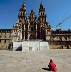  ??  ?? Cattedrale
Una donna a Santiago de Compostela nella piazza Obradoiro deserta (Miguel Riopa/afp)