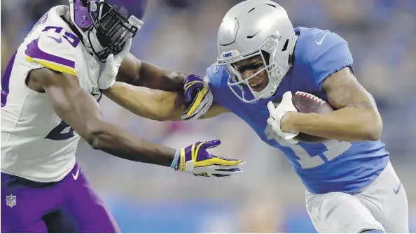  ?? GREGORY SHAMUS/GETTY IMAGES ?? Detroit Lions wide receiver Marvin Jones Jr. tries to fend off Minnesota Vikings cornerback Xavier Rhodes after catching a pass on Thursday in Detroit. Despite a pair of touchdowns by Jones, the Lions lost 30-23 in front of a crowd of 66,613.