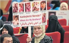  ?? AFP ?? Members of Uighur minority hold up pictures of their relatives detained in China during a press conference in Istanbul on May 10.