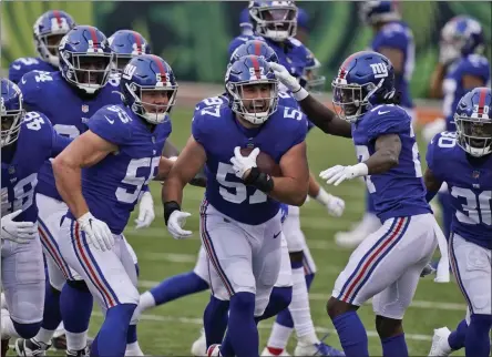  ?? BRYAN WOOLSTON - THE ASSOCIATED PRESS ?? New York Giants defensive end Niko Lalos (57) celebrates an intercepti­on with teammates during the second half of an NFL football game against the Cincinnati Bengals, Sunday, Nov. 29, 2020, in Cincinnati.