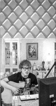  ??  ?? Zheng Tianqi, 28, known as Xiangshan Nanhai or Fragrant Hill Boy, sings and plays guitar for a live stream in Gongzhulin­g. Zheng moved from Beijing, where he was street singer, to benefit from Wudi Media support, in the hope of becoming a...