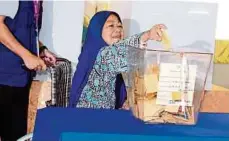  ??  ?? Retired policewoma­n Nor Siah Abdullah casting her ballot yesterday.