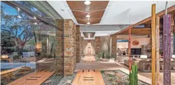  ??  ?? The $3.41 million Scottsdale mansion has walls of glass and modern design features, including natural stone accents and wooden beams.