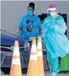  ?? MIKE STOCKER/SUN SENTINEL ?? Health care workers administer free drive-thru COVID-19 tests at the Hard Rock Stadium in Miami Gardens on Wednesday.