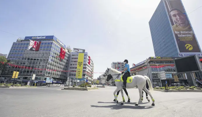  ??  ?? Police officers on horseback patrol the deserted streets of the Turkish capital Ankara, May 19, 2020.