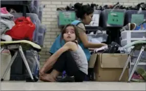  ?? THE ASSOCIATED PRESS ?? A young migrant girl from Central American newly released after processing by the U.S. Customs and Border Patrol is fitted for shoes at the Sacred Heart Community Center in the Rio Grande Valley border city of McAllen, Texas.