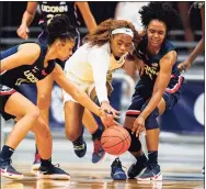  ?? Michael Conroy / Associated Press ?? Butler guard Okako Adika (4) goes for a loose ball between UConn guards Evina Westbrook (22) and Christyn Williams (13) on Saturday.