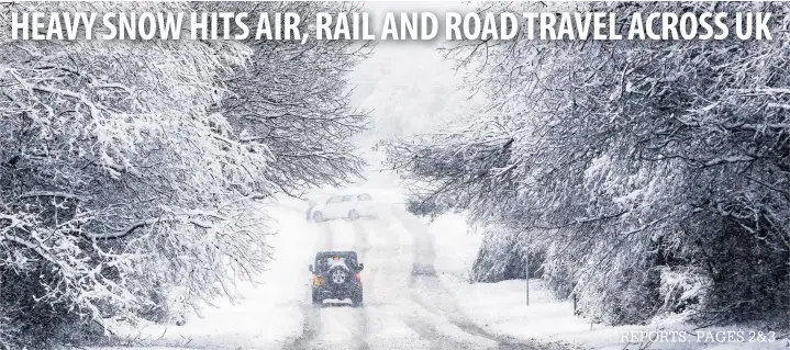  ?? James Davies ?? > Motorists struggle through heavy snowfall on the A4059 near the village of Penderyn, south Wales, yesterday as bad weather caused widespread disruption across the UK