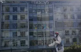  ?? PHOTOS BY JEFF CHIU — THE ASSOCIATED PRESS ?? A pedestrian walks at Union Square near a Macy’s store in San Francisco on Thursday.