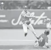  ??  ?? UH shortstop Cooper Coldiron, left, forces out Cincinnati’s R.J. Thompson to start a double play in the third inning, one of three turned by the Cougars.