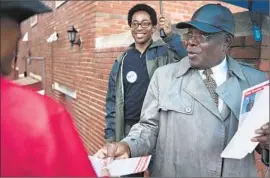  ?? Sid Hastings
European Pressphoto Agency ?? CANDIDATE Lee Smith, handing out voter informatio­n on election day, lost to Wesley Bell, rear. Bell will represent Ward 3, where Michael Brown was killed.