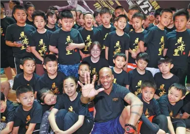  ?? PROVIDED TO CHINA DAILY ?? Former NBA All-Star Stephon Marbury, co-founder and head coach of the new Stronger Me Basketball Training Camp, poses with young players at Sunday’s launch in Beijing.