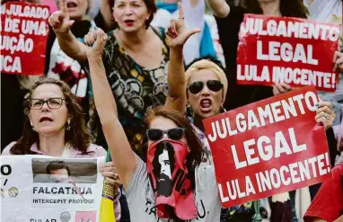  ?? Diego Vara/Reuters ?? Apoiadores de Lula protestam em frente ao prédio do TRF-4, em Porto Alegre