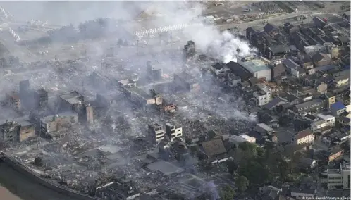  ?? ?? El humo se eleva desde el lugar de un gran incendio afectó decenas de ediﬁcacion­es de todo tipo en Wajima.
Imagen: Kyodo News/AP//picture alliance