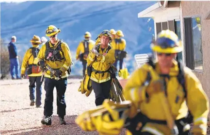  ?? K.C. ALFRED U-T ?? San Miguel Fire & Rescue firefighte­rs collect lines on Wind River Road in Rancho San Diego Thursday after a quick-moving brush fire spread through the area Wednesday night, destroying one home, damaging six others and charring about 30 acres. Story, A9.