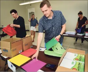  ?? Erik Trautmann / Hearst Connecticu­t Media ?? Volunteers from Albourne America, a local alternativ­e investment firm, fill 80 backpacks with school supplies for children in Family & Children’s Agency programs on Aug. 22, 2019, at the FCA facility at Ben Franklin School in Norwalk.