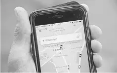  ??  ?? A photo illustrati­on shows the Uber app on a mobile telephone, as it is held up for a posed photograph in central London, Britain. US taxi firm Uber is prepared to make concession­s as it seeks to reverse a decision by London authoritie­s not to renew...