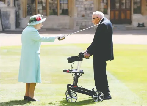  ?? CHRIS JACKSON / POOL VIA REUTERS ?? Queen Elizabeth awards Captain Tom Moore with the insignia of Knight Bachelor at Windsor Castle in July.