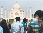  ?? MONEY SHARMA/GETTY-AFP ?? A tourist wears a face mask to protect against air pollution at the Taj Mahal in Agra, about 130 miles from New Delhi.