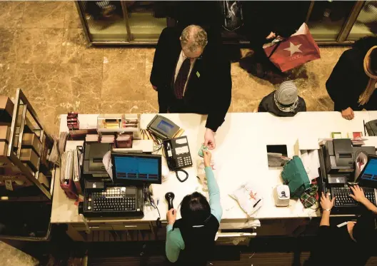  ?? CHRIS HONDROS/GETTY 2009 ?? A shopper pays with a credit card at a Macy’s store in New York City. The average rate on a retail credit card is 26.72%, while a general credit card is around 22.66%.