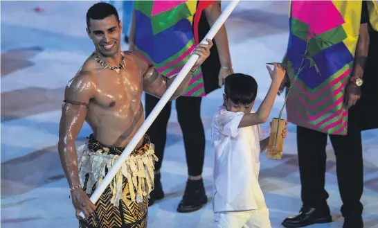  ??  ?? Tonga’s flag bearer Pita Taufatofua leads in his team at the opening of Rio’s Olympic Games.