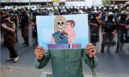  ?? Photograph: Murtaja Lateef/EPA ?? An Iraqi man carries a caricature depicting Emmanuel Macron and his wife Brigitte during a protest in front of the French embassy in Baghdad on Monday.