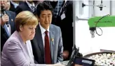  ??  ?? La chancelièr­e allemande Angela Merkel et le Premier ministre japonais Shinzo Abe lors d’une visite au salon des technologi­es CeBit, hier, à Hanovre