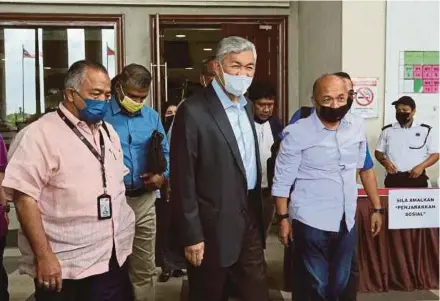 ?? EIZAIRI SHAMSUDIN PIC BY ?? Datuk Seri Dr Ahmad Zahid Hamidi (centre) leaving the High Court in Kuala Lumpur yesterday.