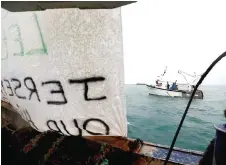  ?? ?? A banner hanging on a French fishing boat as other boats protest in front of the port of Saint Helier off the British island of Jersey.