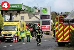  ?? ?? A fire officer walks away from the scene of carnage as ambulance workers survey the scene and a tractor helps to clear the debris