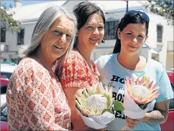  ?? Picture: EUGENE COETZEE ?? FLORAL TRIBUTE: During a break in court proceeding­s yesterday Michelle Inggs, left, and her daughter, Toni Inggs, right, receive flowers from a family friend, Gina de Wet. The flowers were to remember the birthday of Jayde Panayiotou who would have...
