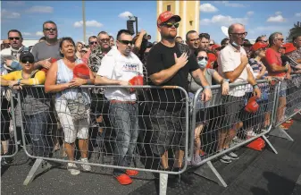  ?? Joe Raedle / Getty Images ?? Supporters of President Trump listen as the national anthem is played before the arrival of the president for a campaign rally at the Ocala Internatio­nal Airport in Florida.