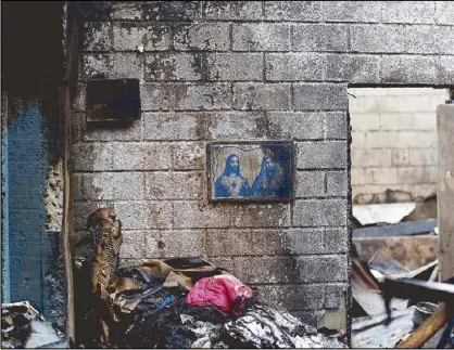  ??  ?? Photo taken in May shows framed images of Jesus and the Virgin Mary on a wall inside a house gutted by a fire in Pasig City.