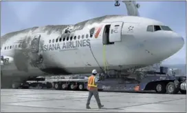  ?? JEFF CHIU/ASSOCIATED PRESS ?? A crew tends to the wreckage Friday of Asiana Flight 214, which crashed on Saturday at San Francisco Internatio­nal Airport. Two people were killed and dozens of others injured, although most suffered minor injuries.