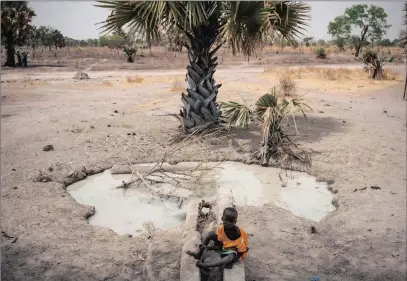  ?? PICTURE: MACKENZIE KNOWLES-COURSIN / UNICEF VIA AP ?? A boy sits next to a stagnant pool of water in Aweil, South Sudan. On World Water Day yesterday, more than 5 million people in South Sudan lacked access to safe, clean water, compoundin­g the problems of famine and civil war, according to Unicef.